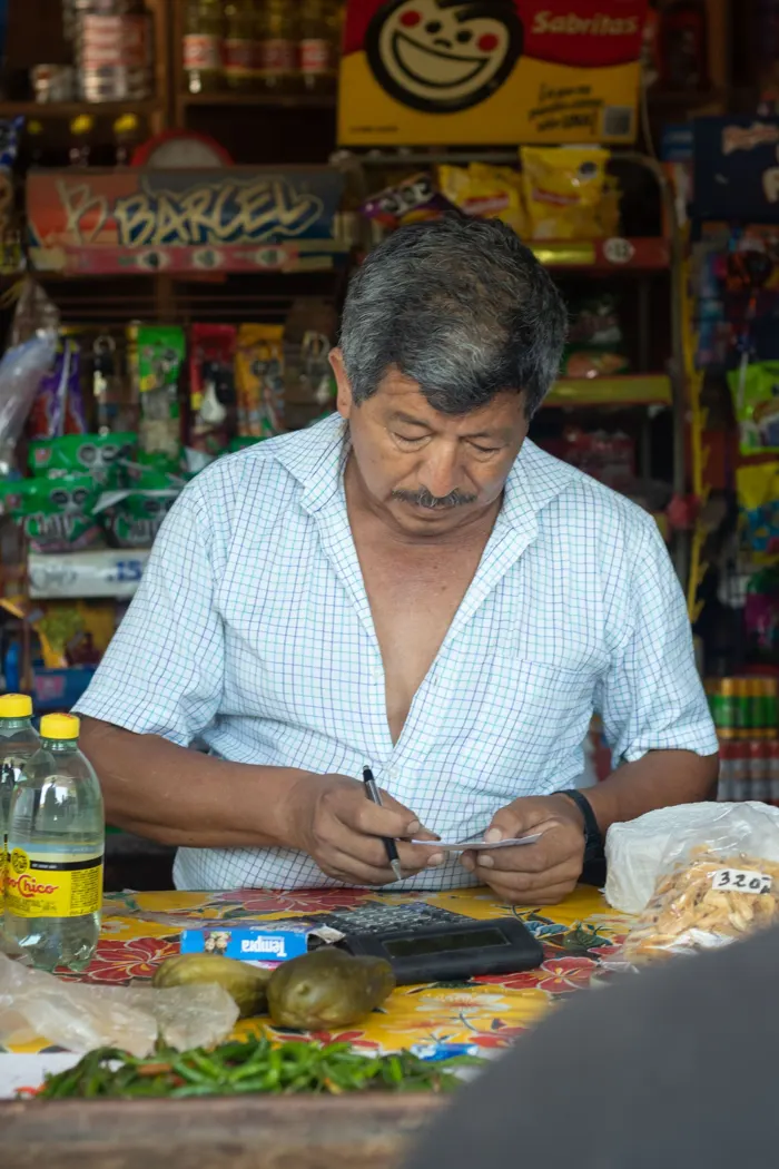 Dueño de tienda de abarrotes atendiendo